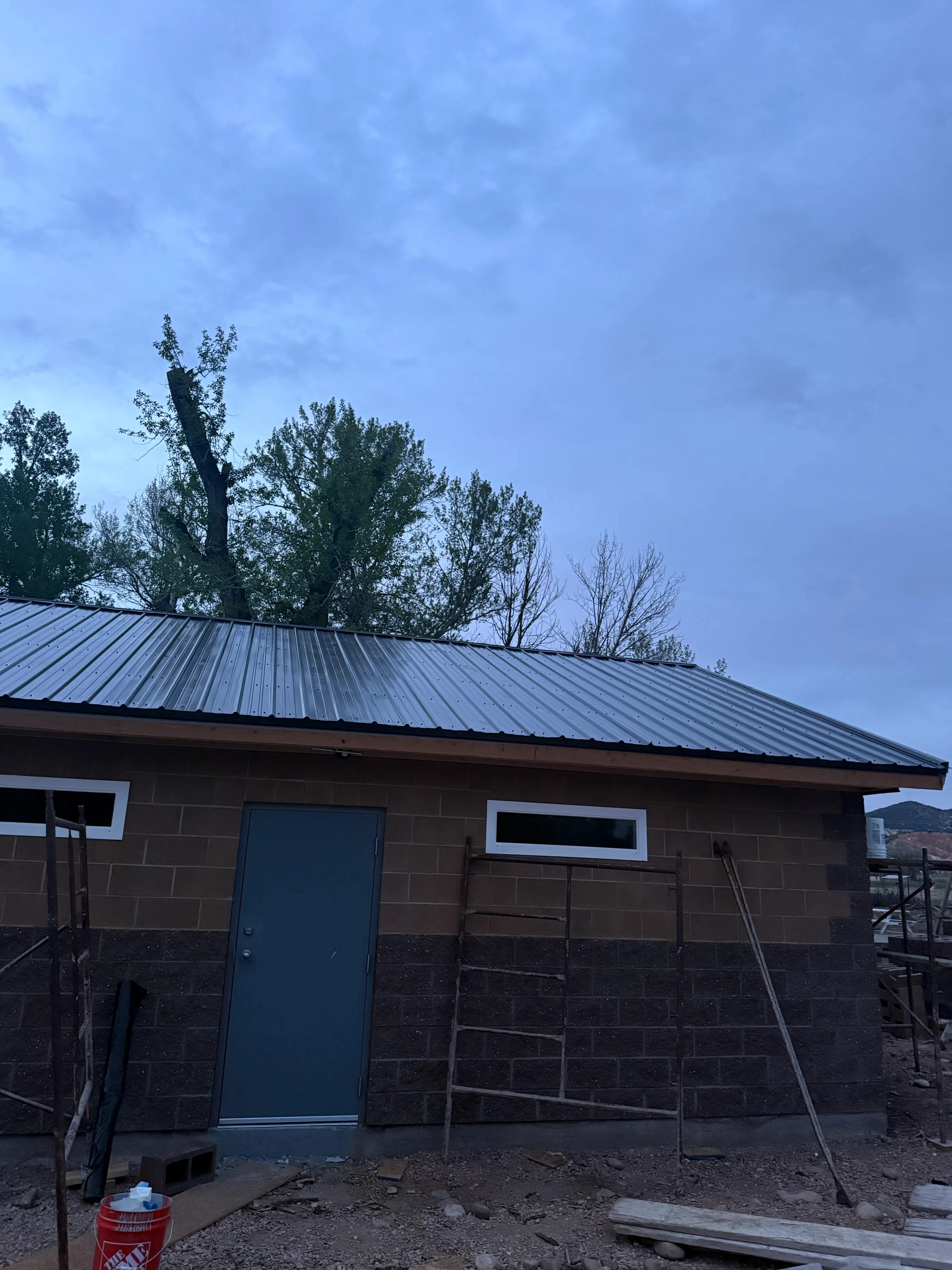Concrete block building with standing seam metal roof and blue door