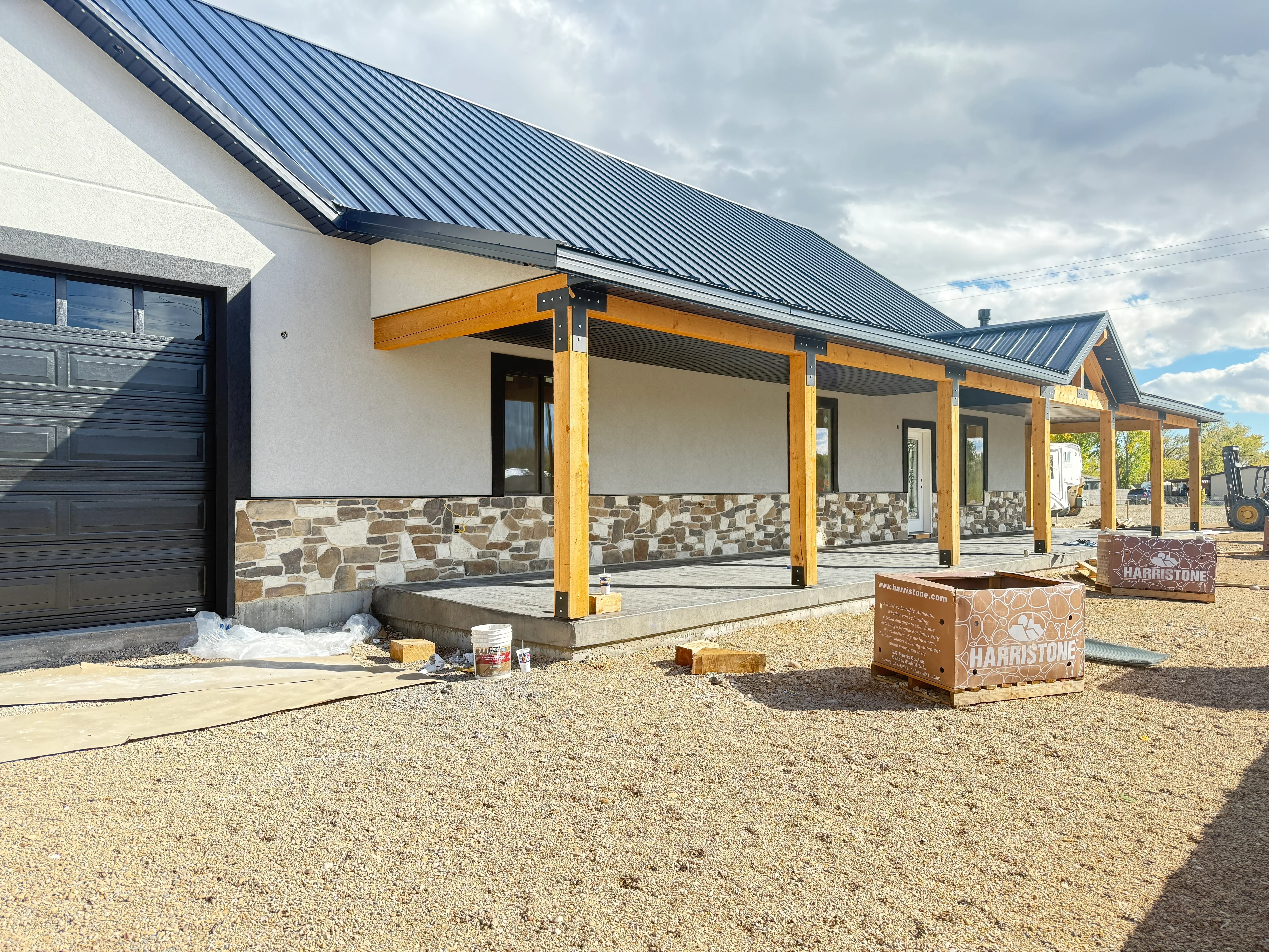 Stone veneer facade on farmhouse with mixed fieldstone and timber pergola detail