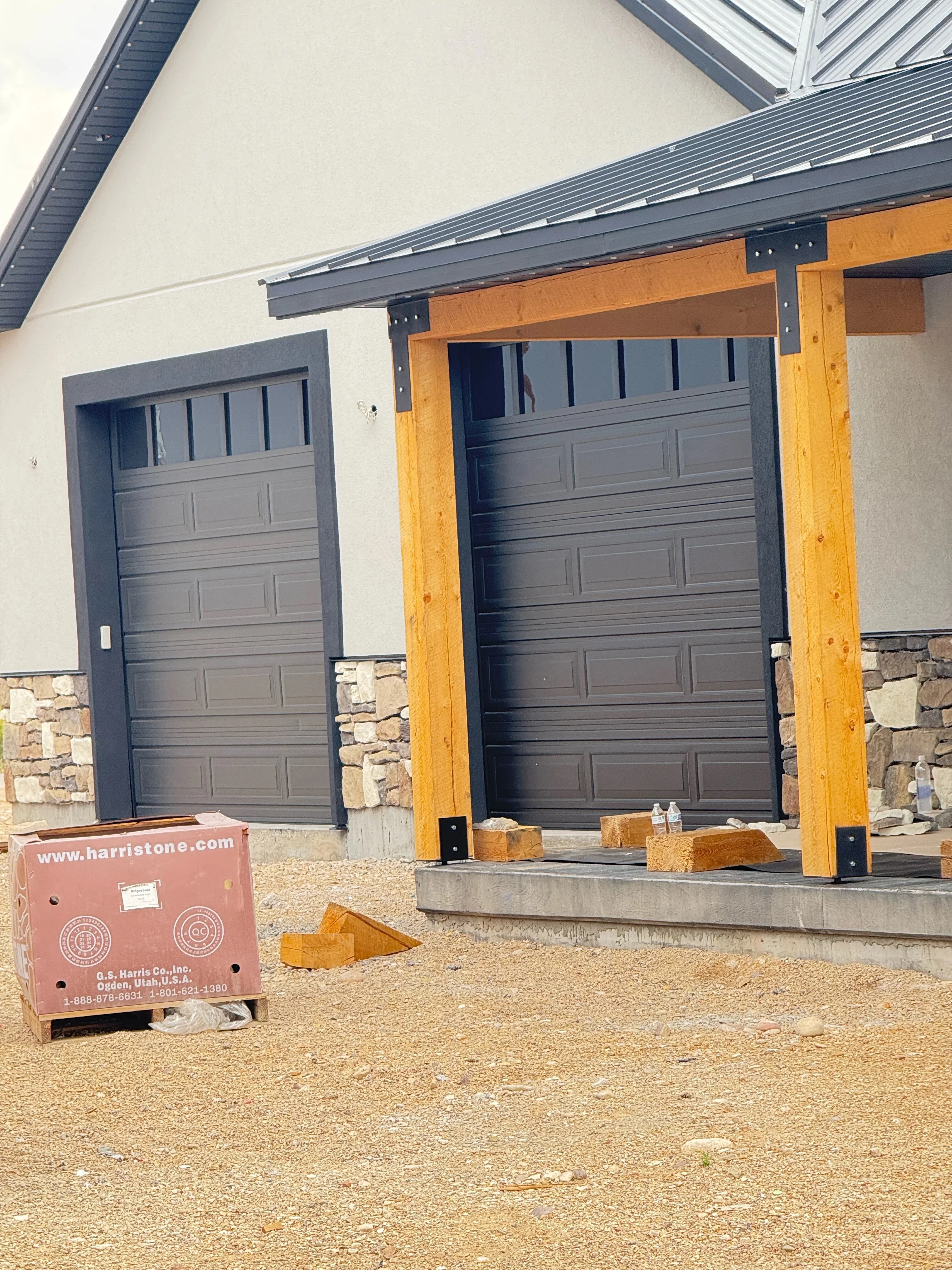 Stone veneer garage entry with timber posts and concrete pad installation